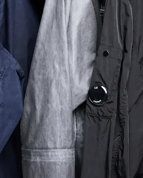 Three different colors of C.P. Company Jackets with Google hanging on a rack