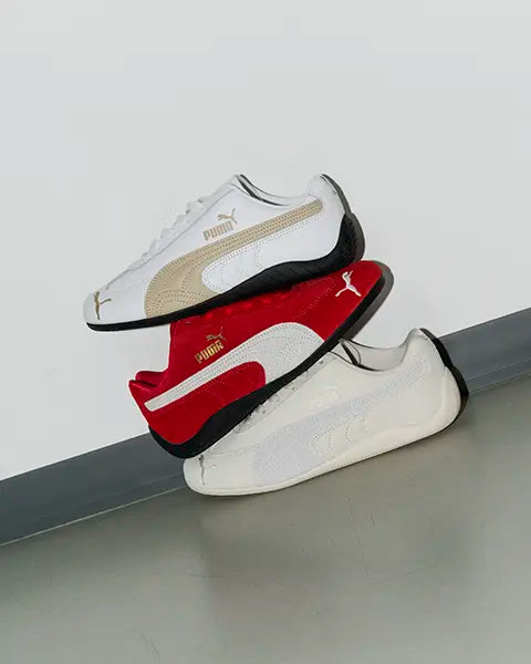 three different colorways of Puma speedcat low profile sneakers standing on a wall